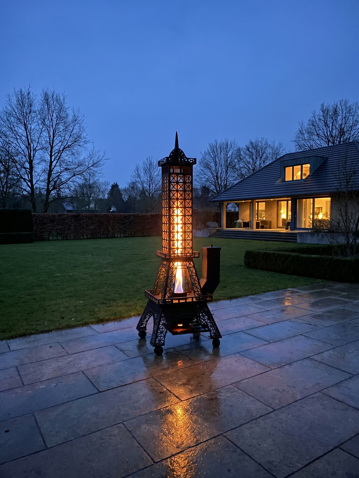 Der brennende Feuerturm auf einer weiten Gartenterrasse in der blauen Stunde